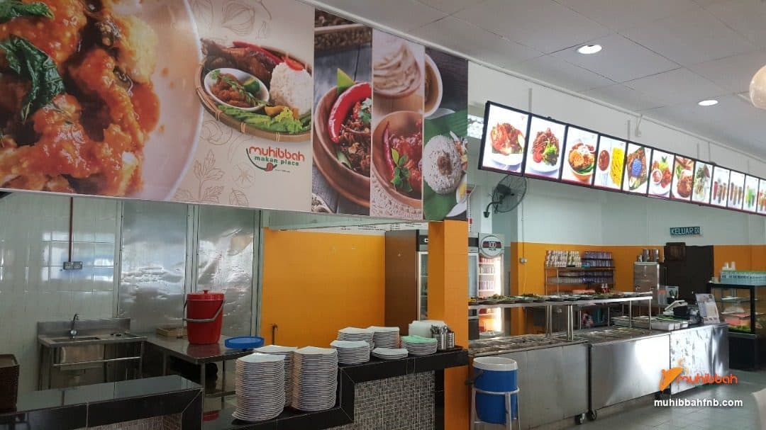 Cafeteria counter and illuminated food display wall in a staff dining hall