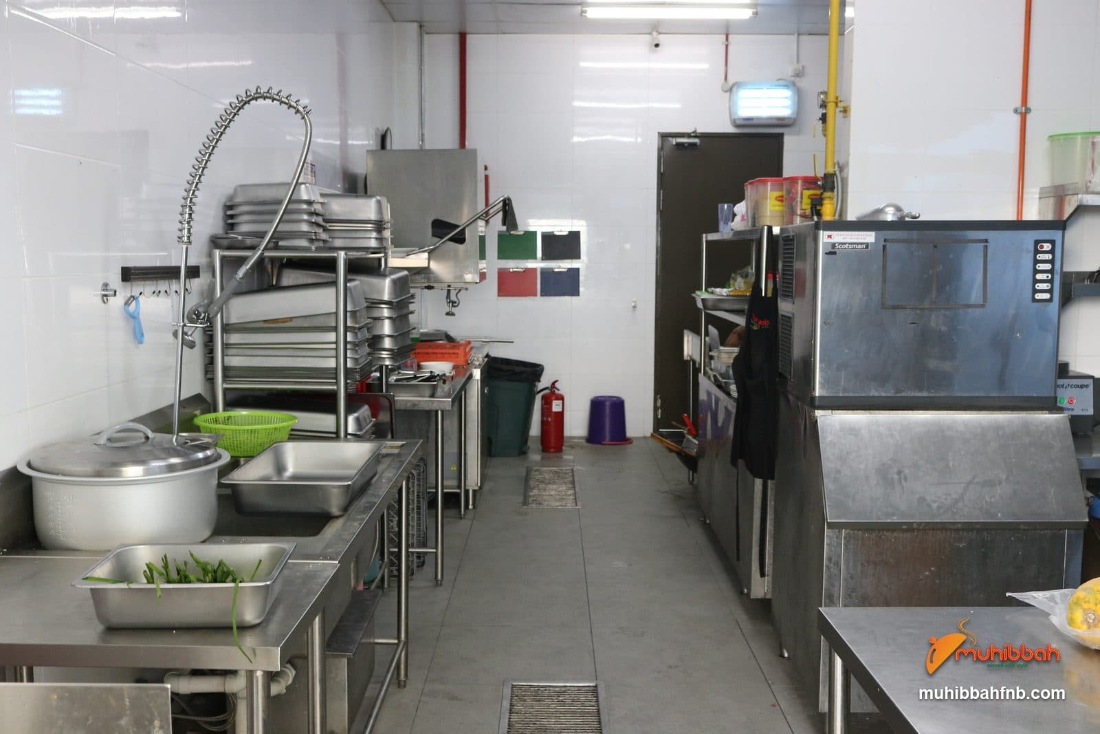 Stainless steel wash-up area with colour-coded chopping boards and floor drainage